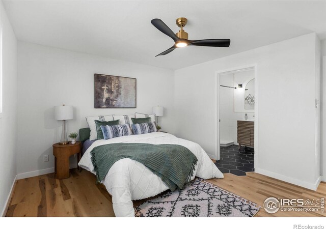 bedroom featuring ceiling fan, connected bathroom, baseboards, and wood finished floors