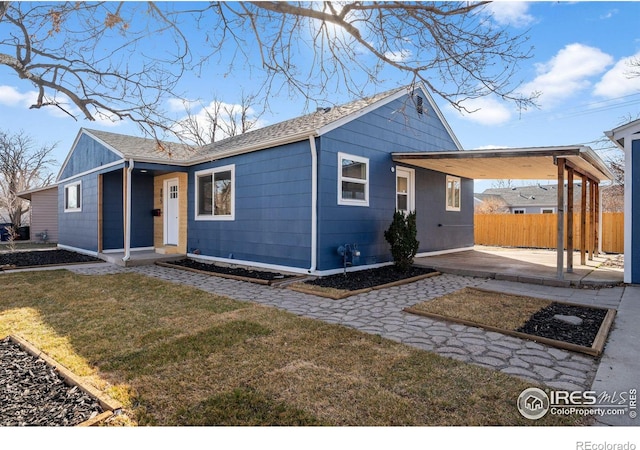 view of front of home featuring a patio area, fence, and a front yard