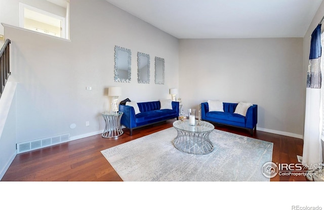 living area with visible vents, baseboards, and wood finished floors