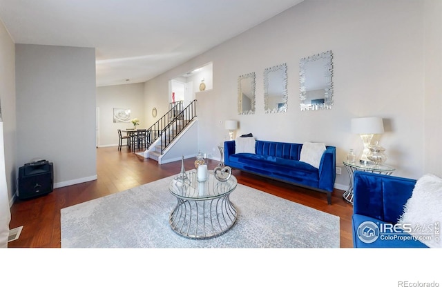 living room with stairway, wood finished floors, and baseboards