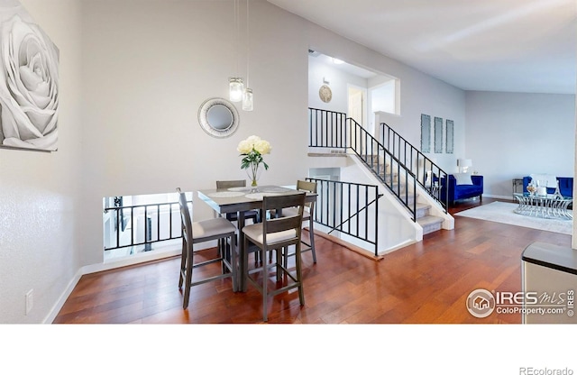 dining area with stairway, baseboards, and wood finished floors