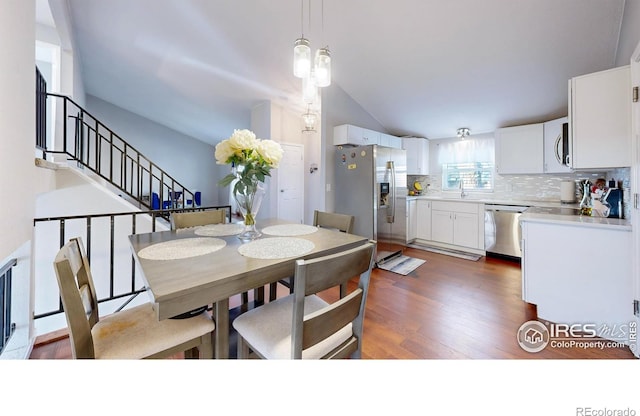 dining space featuring stairs, lofted ceiling, and dark wood-style flooring