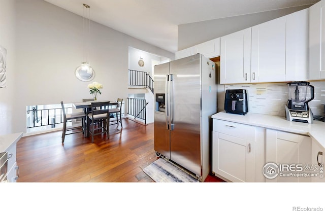 kitchen with white cabinetry, light countertops, wood finished floors, and stainless steel fridge with ice dispenser