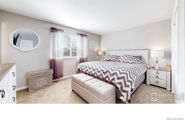 bedroom with baseboards and light carpet