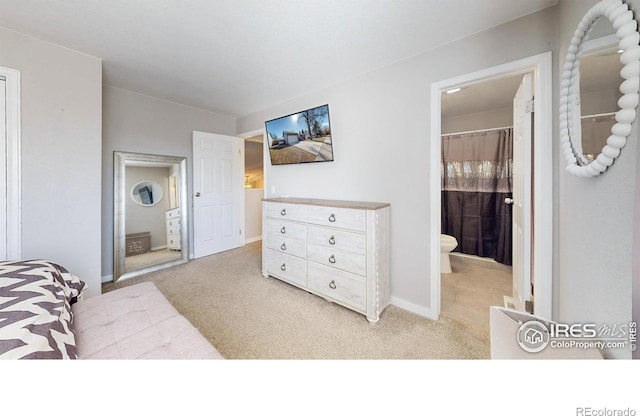 bedroom featuring light colored carpet and ensuite bath