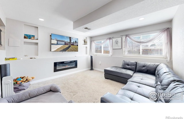 living area with recessed lighting, baseboards, carpet, and a glass covered fireplace