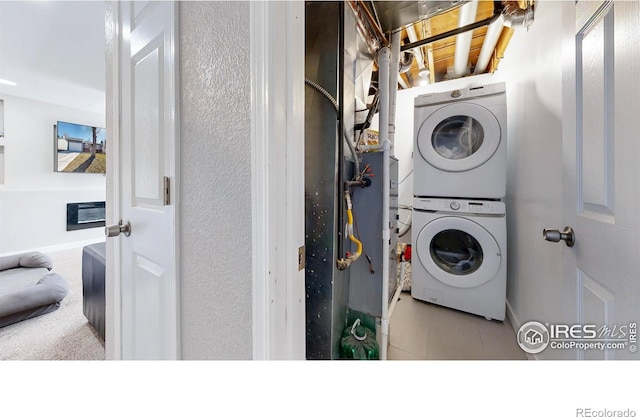 washroom with tile patterned flooring, laundry area, and stacked washer / drying machine