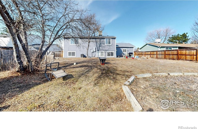 rear view of property featuring a fenced backyard