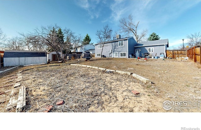 exterior space with a storage unit, an outdoor structure, and fence