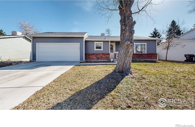 single story home with a garage, a front yard, brick siding, and driveway