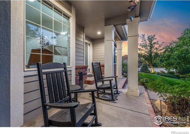 patio terrace at dusk featuring a porch