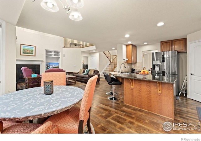 dining area with dark wood finished floors, recessed lighting, and stairs