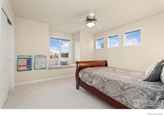 bedroom featuring a closet, baseboards, carpet, and a ceiling fan