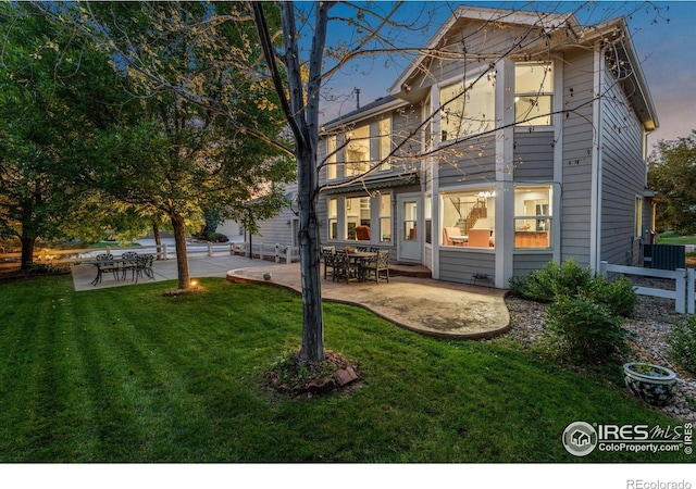 back of property featuring a patio, a lawn, and fence