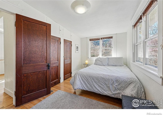 bedroom featuring light wood-type flooring and baseboards