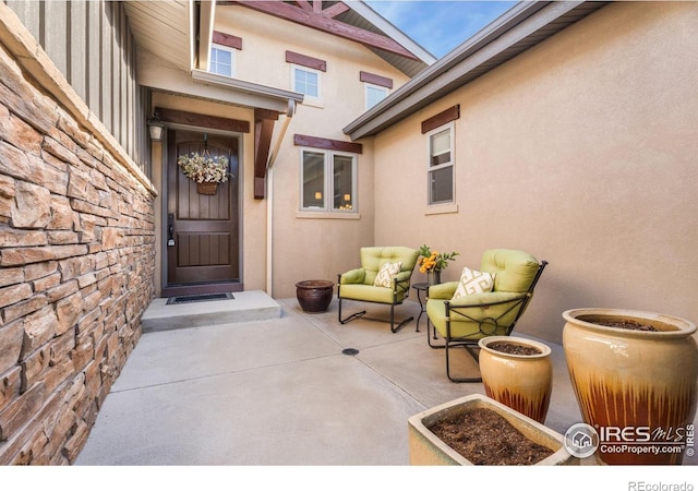 property entrance with stone siding and stucco siding