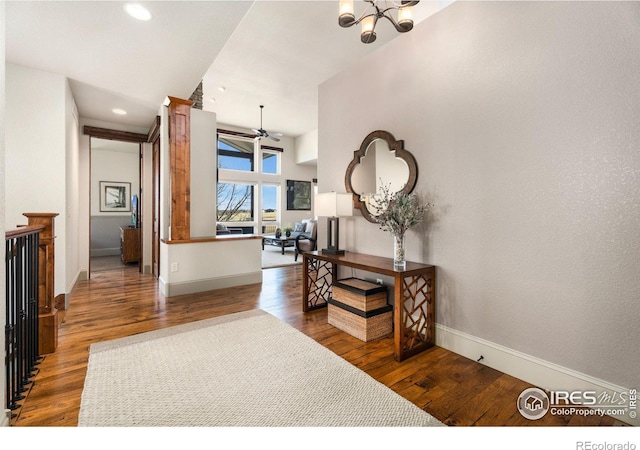 hall featuring recessed lighting, baseboards, an inviting chandelier, and wood finished floors