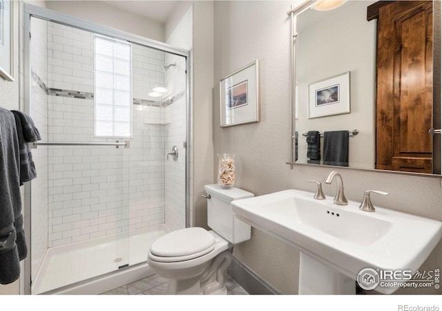 full bathroom with toilet, a textured wall, a stall shower, and a sink