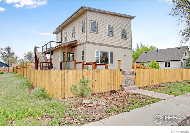 229 3rd St, Fort Collins, CO 80524 - view of front of property with a fenced front yard, a gate, stucco siding, and stairs