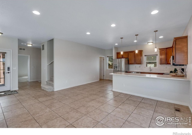 229 3rd St, Fort Collins, CO 80524 - kitchen featuring appliances with stainless steel finishes, light countertops, brown cabinets, a sink, and a peninsula