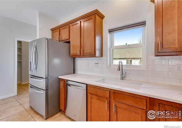 229 3rd St, Fort Collins, CO 80524 - kitchen with stainless steel appliances, a sink, brown cabinets, decorative backsplash, and light tile patterned floors