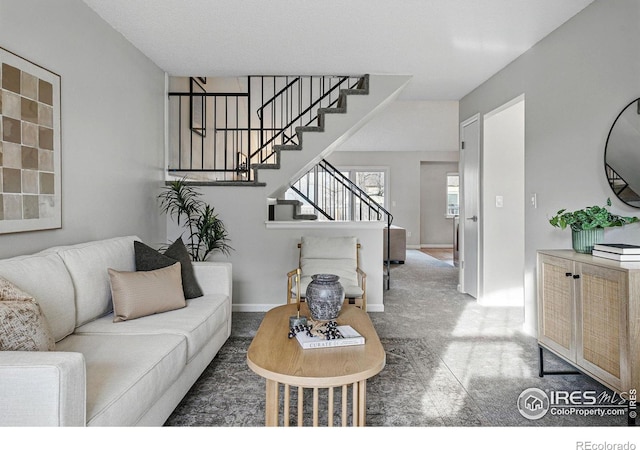 living room featuring stairway and baseboards