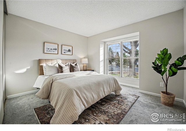 carpeted bedroom featuring baseboards and a textured ceiling