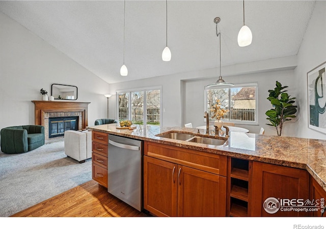 kitchen with brown cabinets, a sink, hanging light fixtures, dishwasher, and open floor plan