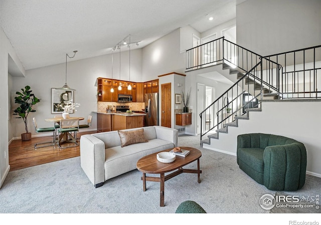 carpeted living room featuring recessed lighting, baseboards, high vaulted ceiling, and stairs