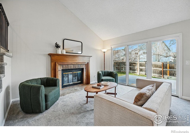 carpeted living area featuring high vaulted ceiling, a fireplace, baseboards, and a textured ceiling