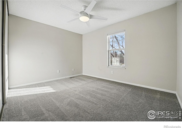 empty room with a ceiling fan, carpet, baseboards, and a textured ceiling