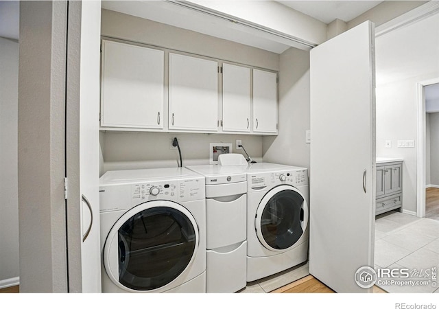 clothes washing area with cabinet space and washing machine and clothes dryer