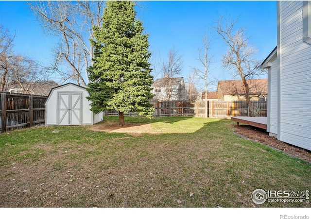 view of yard with an outdoor structure, a storage unit, and a fenced backyard