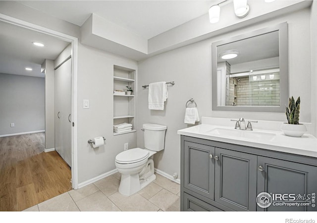 full bath featuring vanity, built in features, baseboards, tile patterned flooring, and toilet