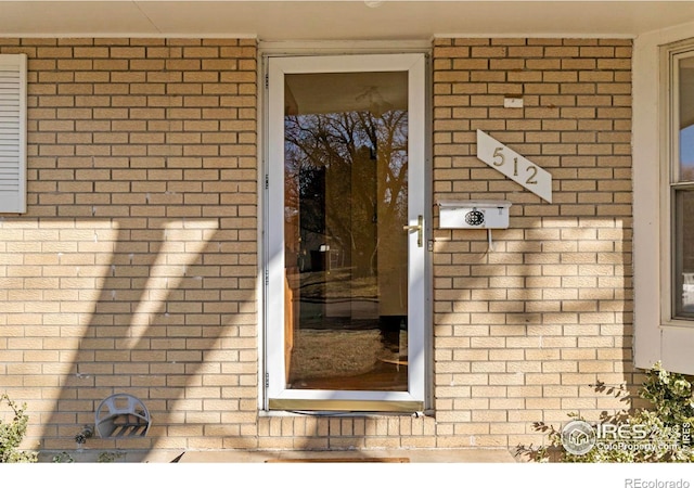 property entrance featuring brick siding