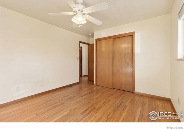 unfurnished bedroom featuring visible vents, baseboards, light wood-style flooring, ceiling fan, and a closet