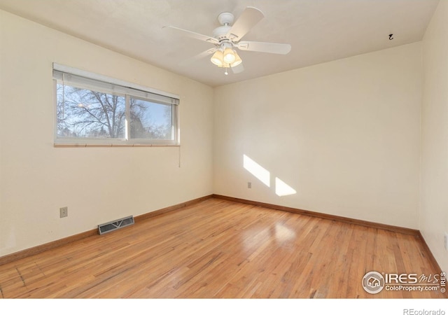 empty room with light wood-style flooring, baseboards, and visible vents