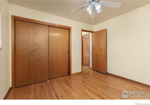 unfurnished bedroom featuring a ceiling fan, baseboards, a closet, and light wood finished floors