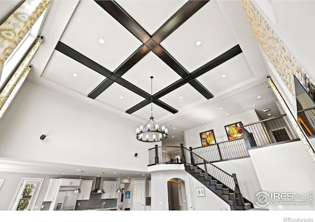 1440 Eversole Dr, Broomfield, CO 80023 - room details featuring coffered ceiling, recessed lighting, arched walkways, decorative backsplash, and wall chimney exhaust hood