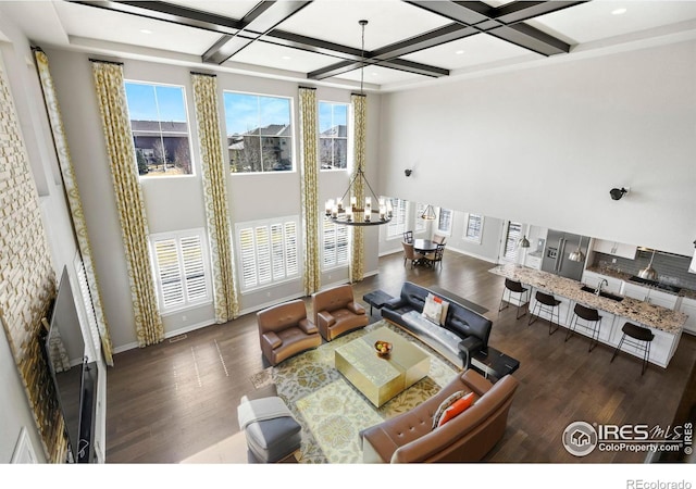 1440 Eversole Dr, Broomfield, CO 80023 - living room featuring wood finished floors, coffered ceiling, a chandelier, and a towering ceiling