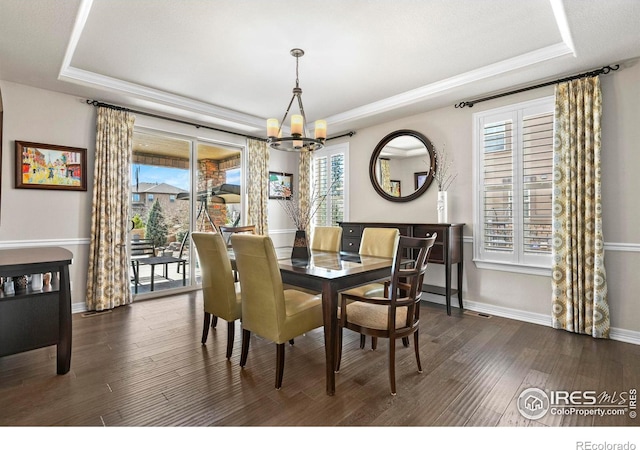 1440 Eversole Dr, Broomfield, CO 80023 - dining room featuring baseboards, a tray ceiling, dark wood-style flooring, ornamental molding, and a chandelier