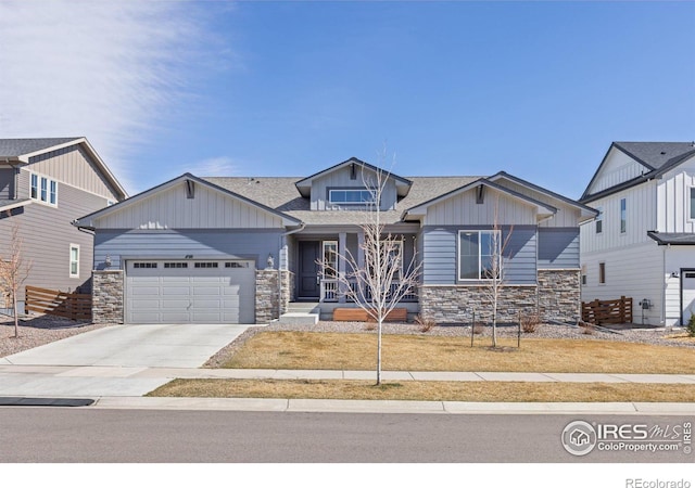 craftsman-style home featuring board and batten siding, a garage, stone siding, and driveway