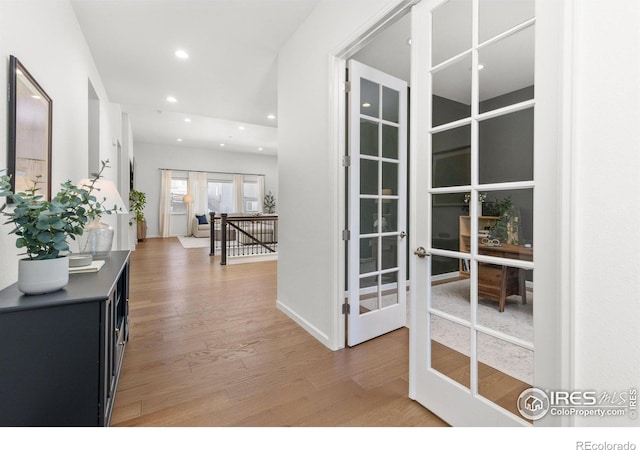 corridor with recessed lighting, french doors, an upstairs landing, and light wood-style floors