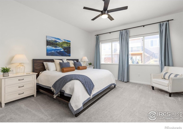 bedroom with light colored carpet, a ceiling fan, and baseboards