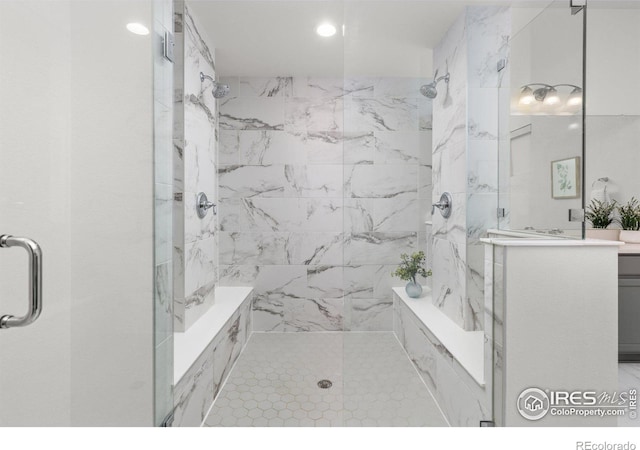 bathroom with a marble finish shower and vanity