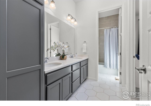 full bath with a sink, a shower with shower curtain, and tile patterned floors