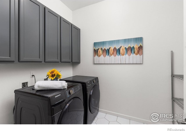 laundry area with baseboards, cabinet space, and separate washer and dryer