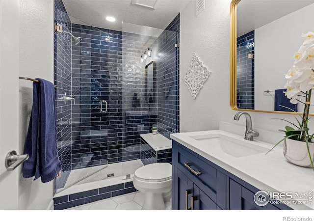 full bath with visible vents, toilet, a textured ceiling, a shower stall, and vanity