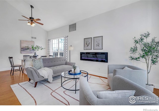 living room featuring baseboards, wood finished floors, visible vents, and ceiling fan