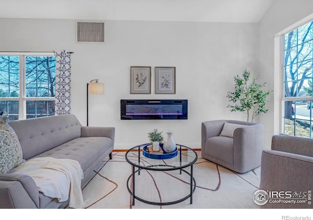 living room featuring wood finished floors, visible vents, and baseboards